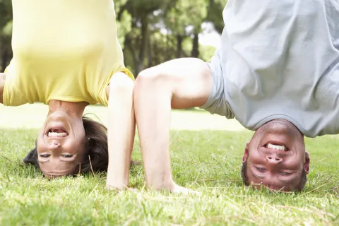 Mann und Frau machen Kopfstand, lachen