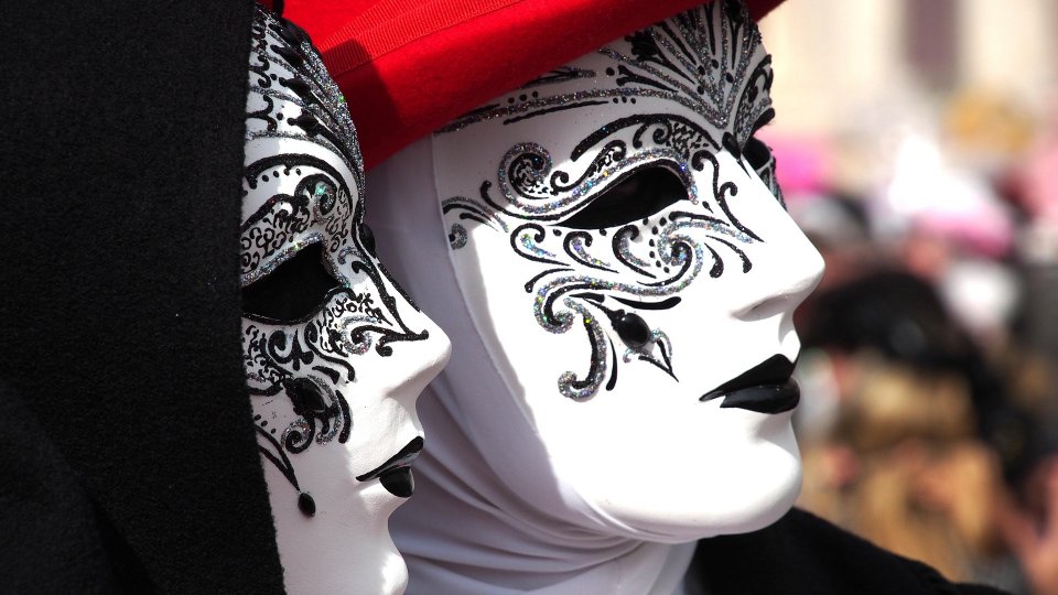 Paar mit weißen Masken mit schwarzer Verzierung um die Augen