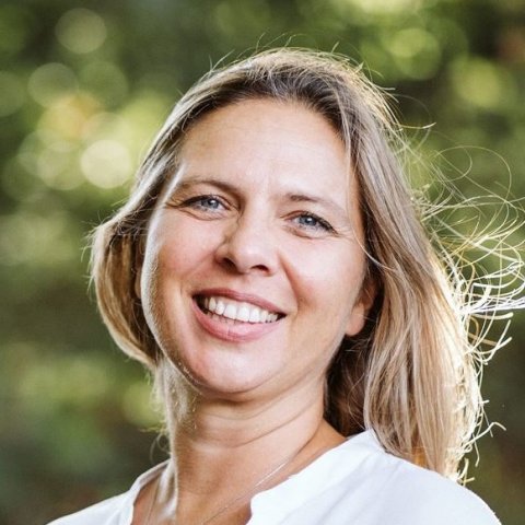 blonde Frau mit langen Haaren lächelt