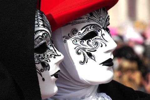 Paar mit weißen Masken mit schwarzer Verzierung um die Augen
