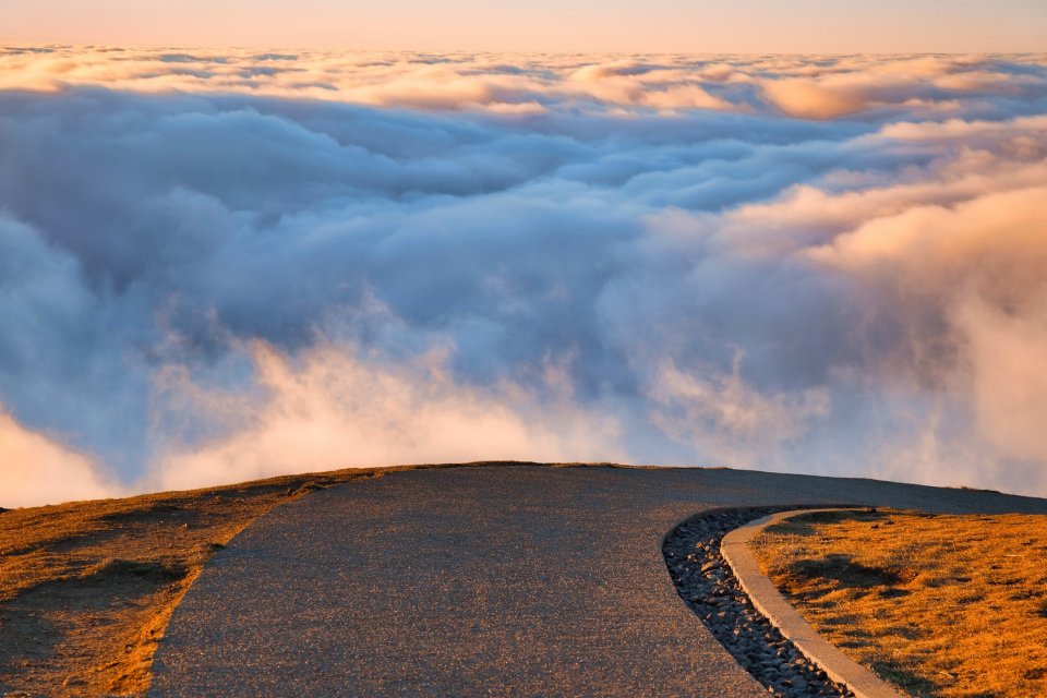 Kurvige Straße im Gebirge mit Blick auf Wolken