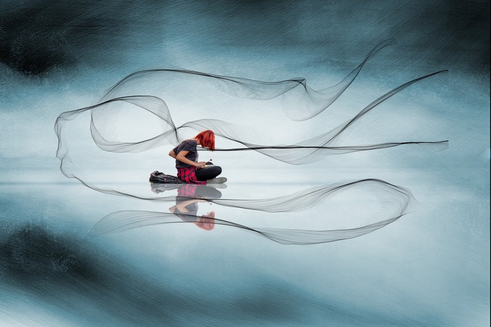 Junge Frau sitzt im Schneidersitz am Boden und spielt Xylophon