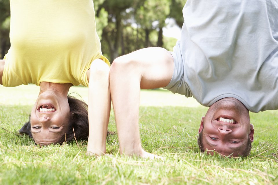 Mann und Frau machen Kopfstand, lachen